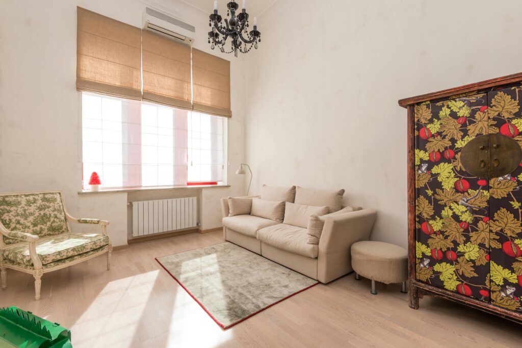 Inviting living room featuring a vintage chair and floral cabinet with abundant natural light.